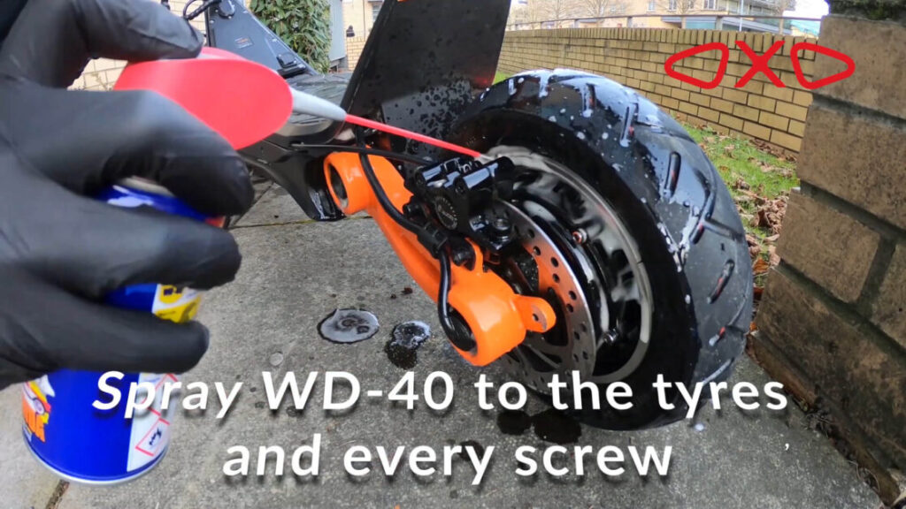 man uses wd-40 to grease the wheel of electric scooter