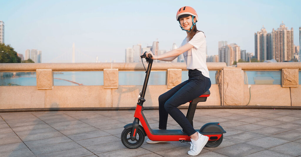 woman sitting on a red electric scooter with a seat