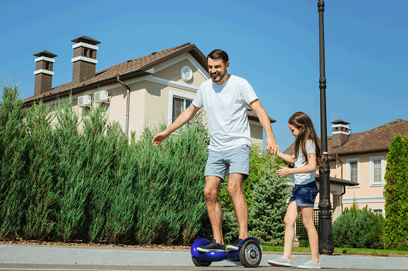 A man standing on a hoverboard and testing out the hoverboard weight limit while holding the daughter's hand at the same time.