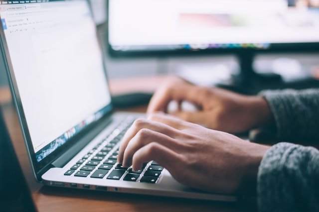 man writing something on lap-top