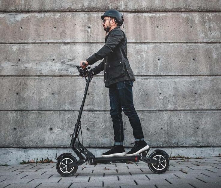 man with a helmet riding with Apollo electric scooter