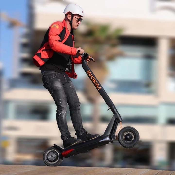 A man jumps with an Inokim OX electric scooter