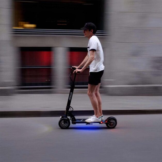 A man is riding with Apollo City electric scooter.