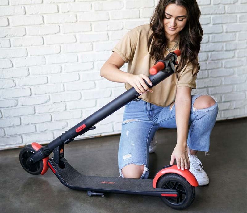 A woman is folding a ninebot ES1L kickscooter 