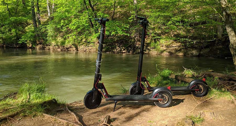 2 gotrax scooters next to the pond