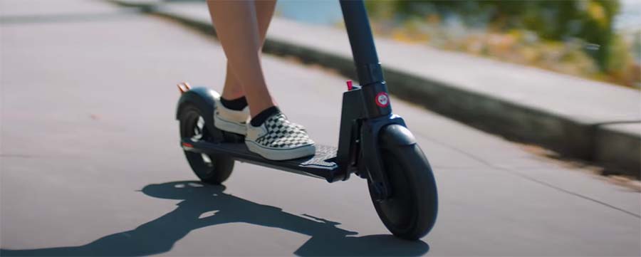 Girls is riding with an electric scooters.
