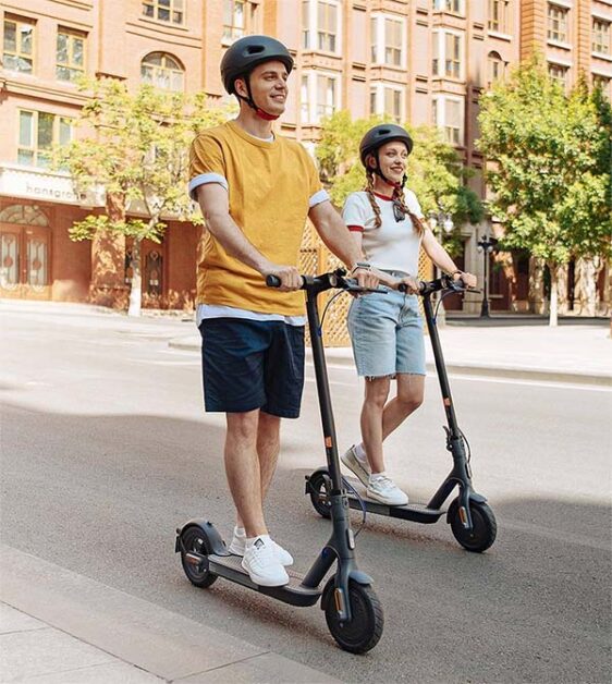 man and woman riding with electric scooters