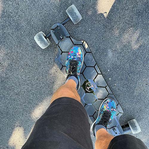 A guy is riding with Halo Board Beast on a smooth asphalt.