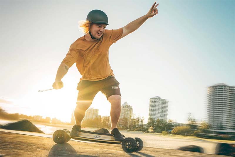 man is taking a corner with electric skateboard