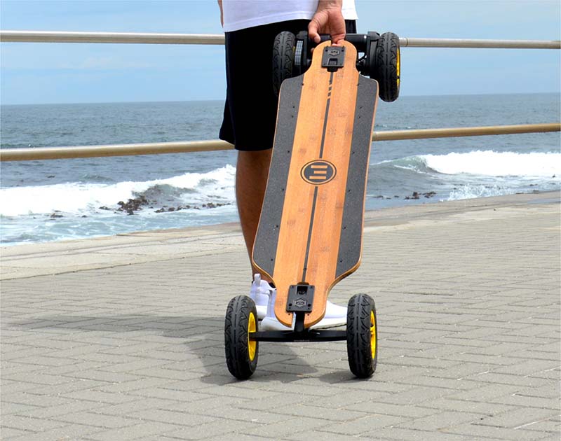 Man carries an electric skateboard behind him