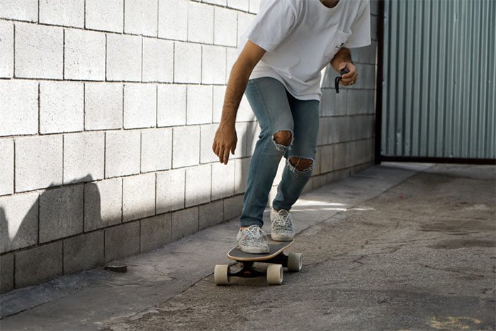 man riding with razor e-board