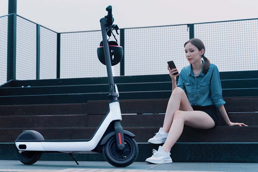 Woman waiting next to the electric scooter