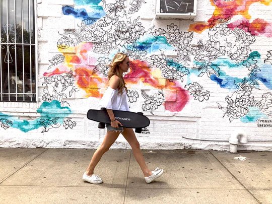 Woman carrying electric skateboard