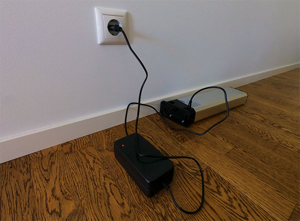 A detachable e-bike battery charging in the livingroom.