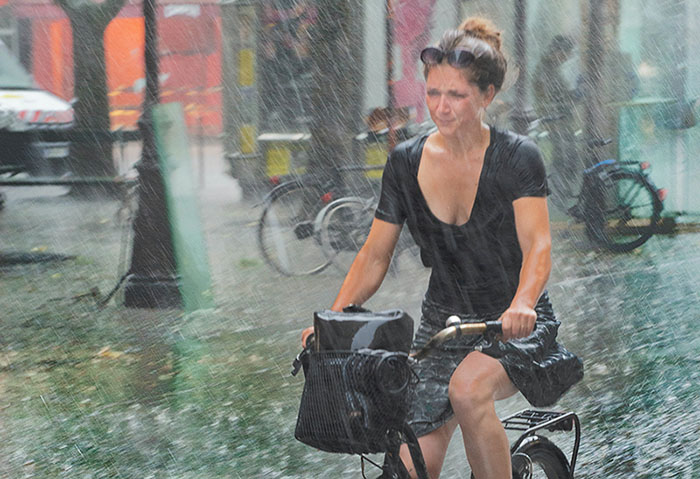 A woman riding an ebike in the heavy rain