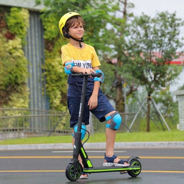 Boy standing next to his Anyhill Um-3 electric kick scooter