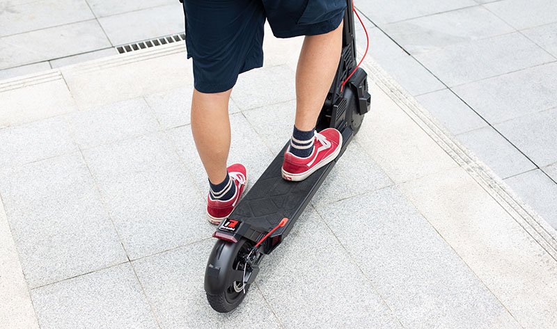 man standing on the deck of electric kick scooter