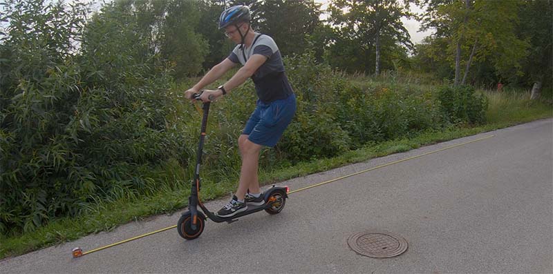 Man is riding with an electric scooter and testing the brakes