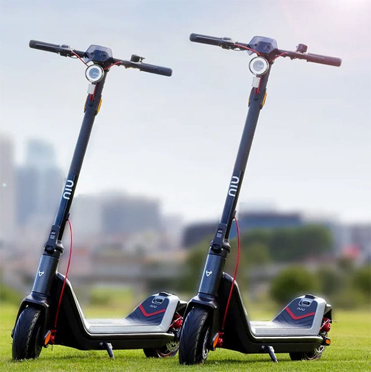 twi Niu electric scooters on a grass