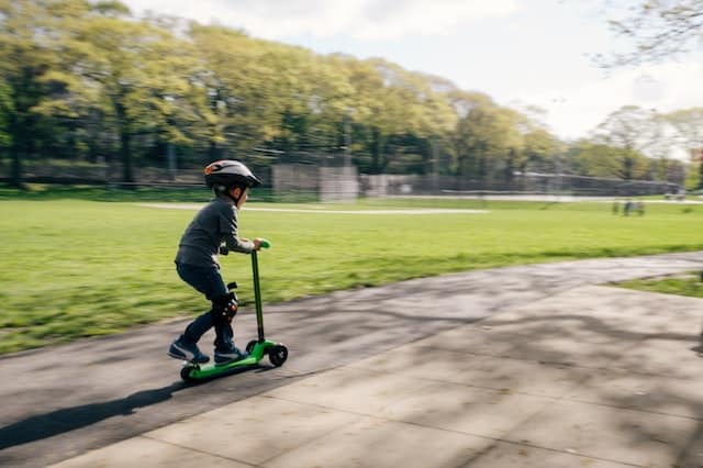 small kid is riding with an electric scooter