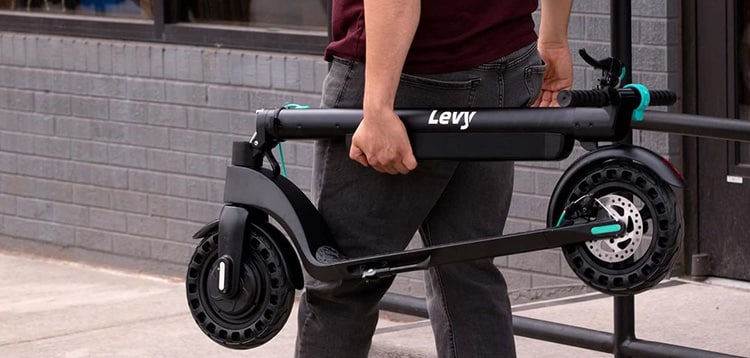 man carrying a levy electric scooter