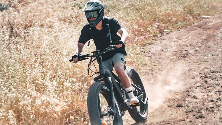 man with a helmet climbing a hill with himiway cobra e-bike
