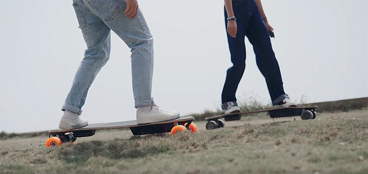 people riding e-skateboards on the grass