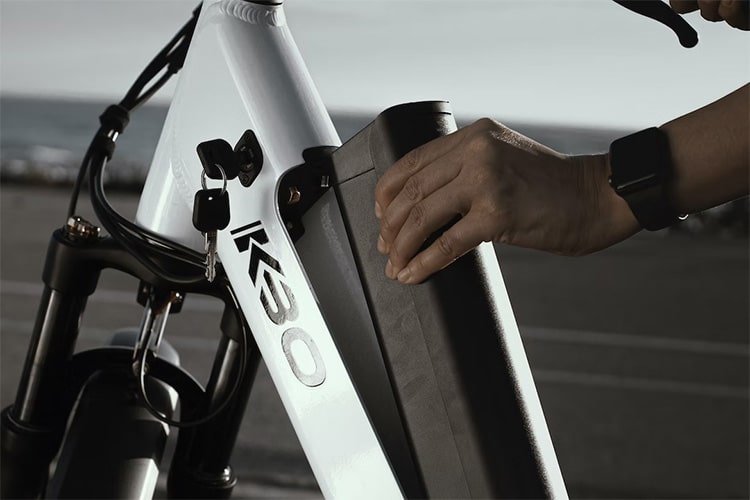 man removes a battery from an electric bike