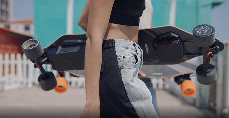 woman carrying electric skateboard