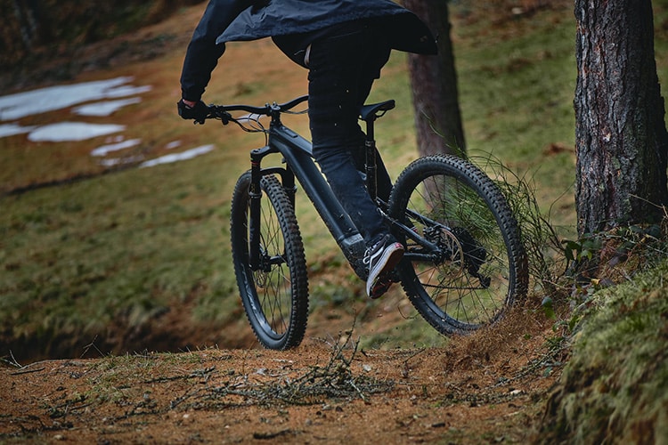 elderly man riding an electric mountain bike in the forest