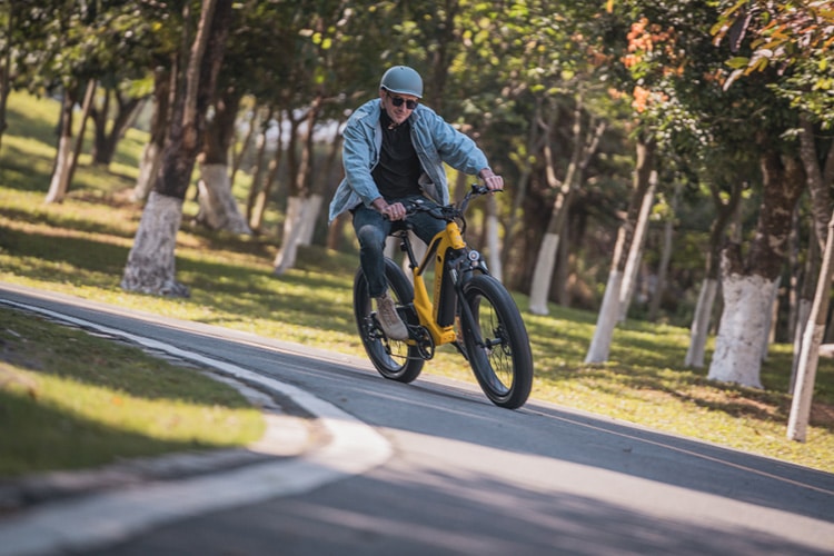 man taking a corner with yellow electric bike