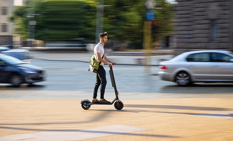 man riding a turboant e-scooter on the public street