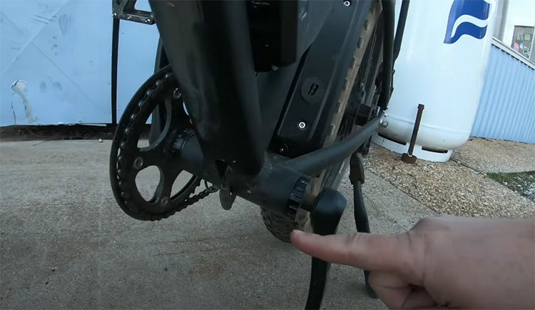 man shows where the torque sensor is on an electric bike