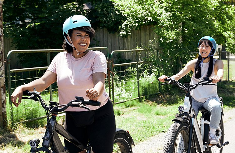 2 women riding with rad power bikes and laughing