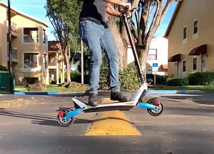 man rides over the the curb with varla pegasus e-scooter