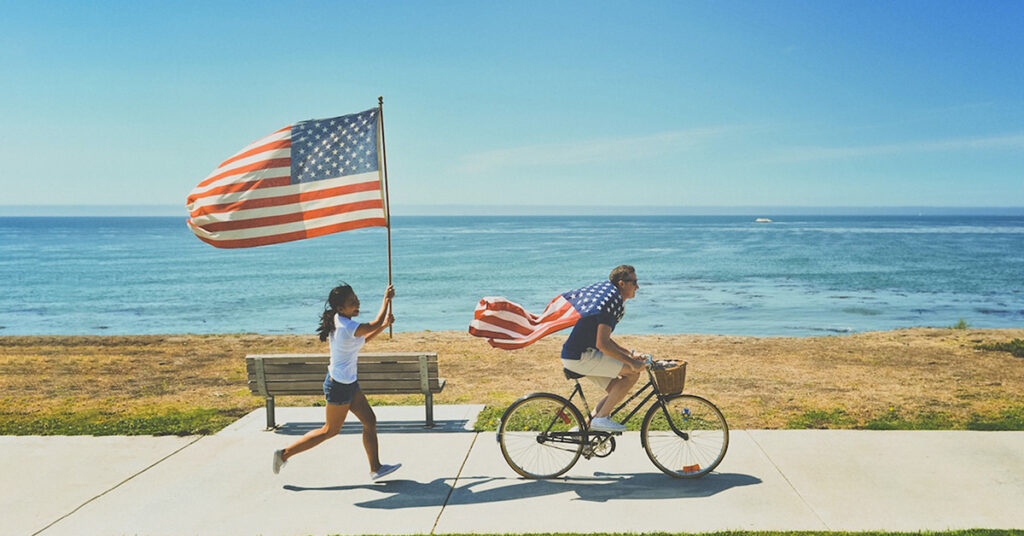 man riding an electric bike with usa flag on the shoulders