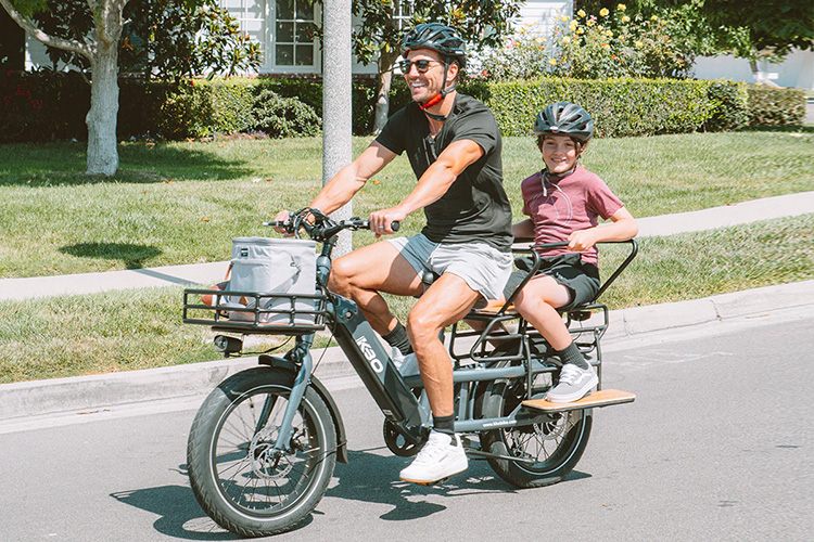 man hauling a kid with cargo electric bike