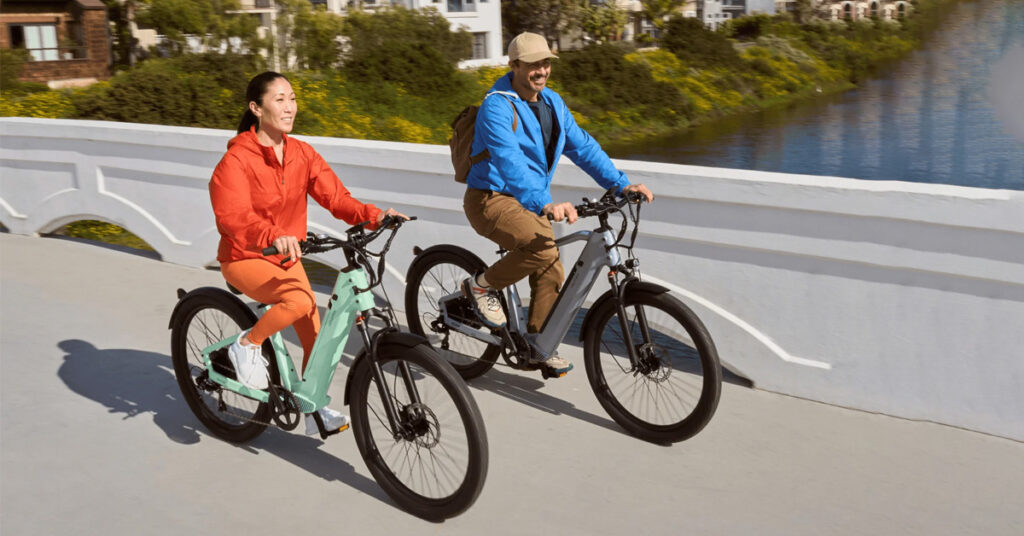 man and woman riding with velotric discover e-bikes