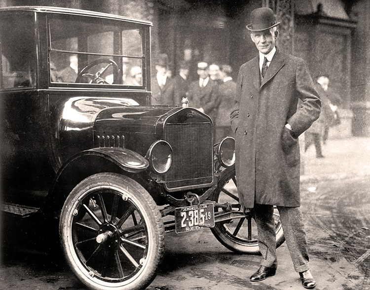 henry ford standing next to the model T