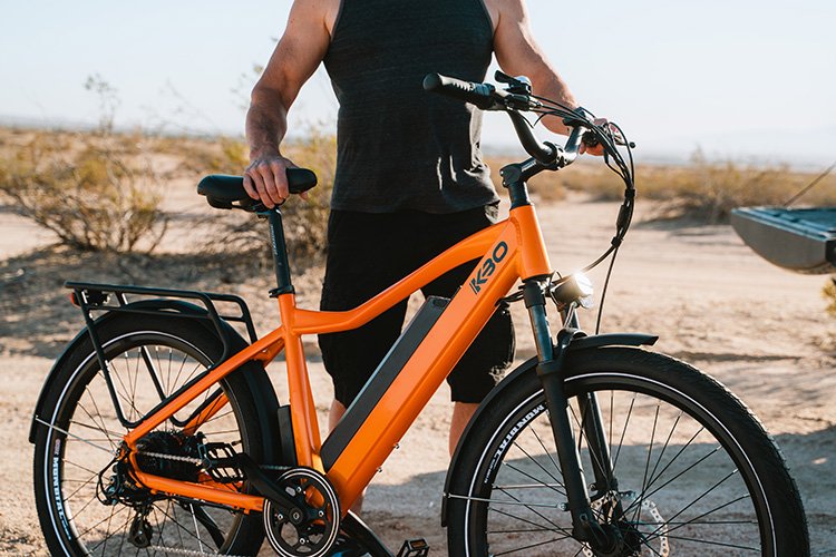 athletic man standing next to the kbo breeze commuter electric bike