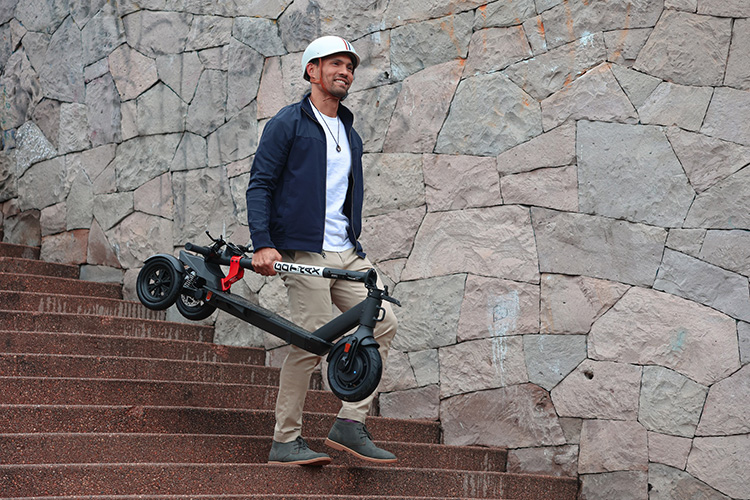 man carrying a 3-wheeled electric scooter