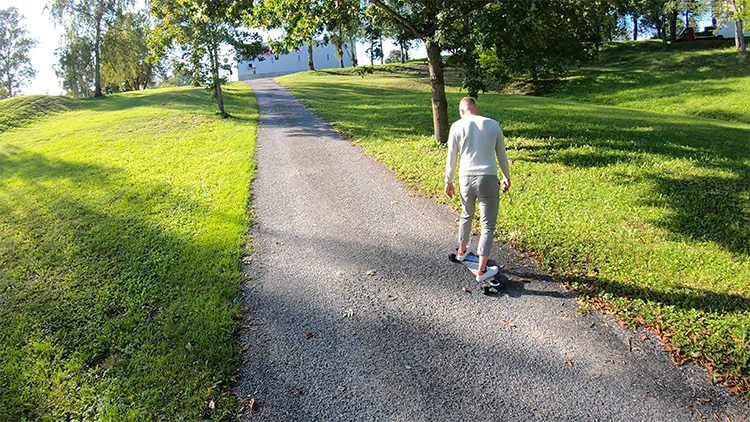 man riding uphill wit a GPad Blade e-skateboard