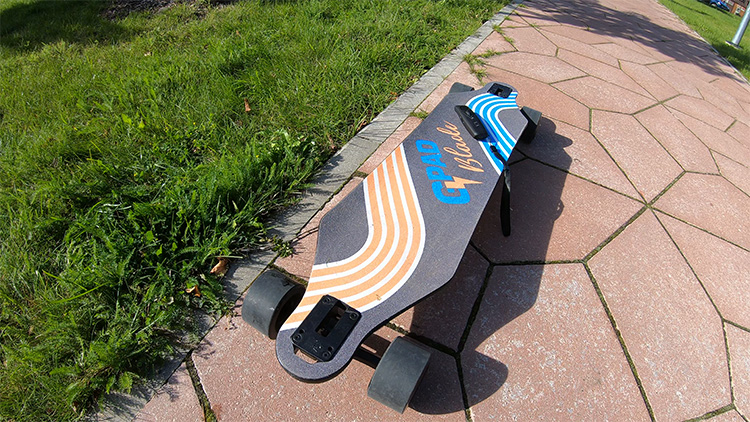 gpad blade electric skateboard on a pavement with remote on the deck