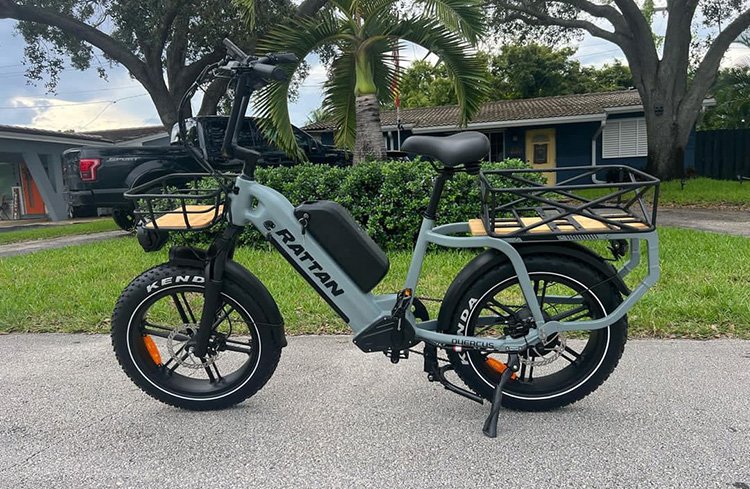 rattan cargo bike with a basket in front of the house