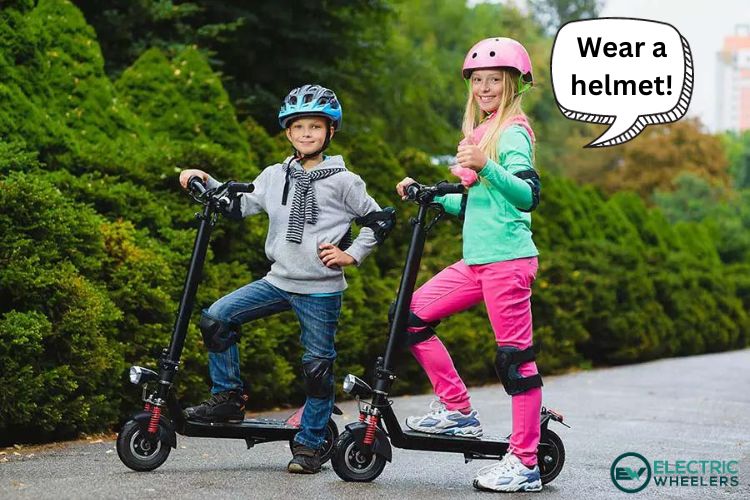 Kids with helmets and other safety gear posing with their electric scooters